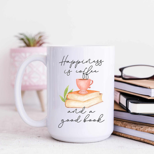 A white mug that reads happiness is coffee and a good book in a script font