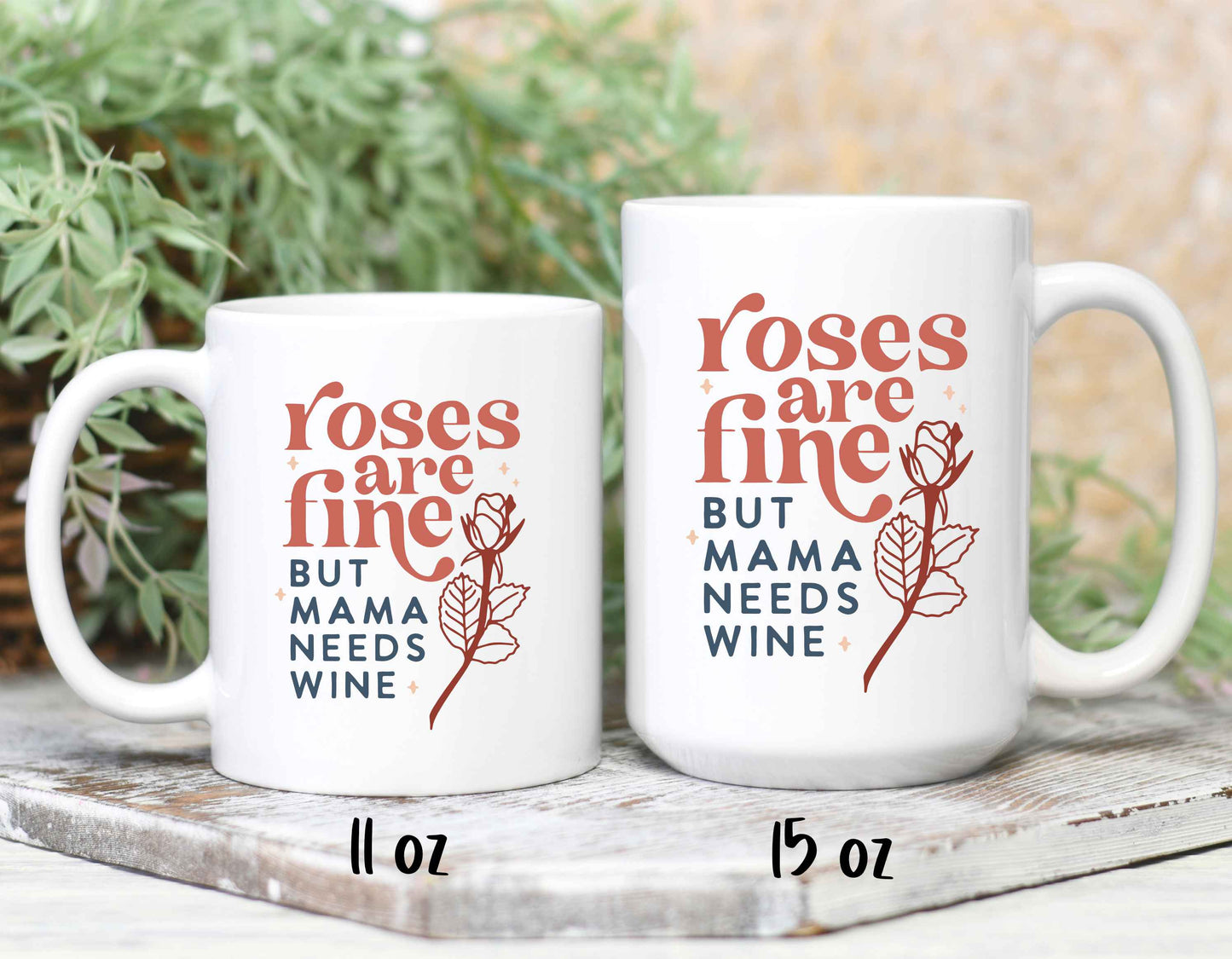 Two sizes of coffee mugs printed with "roses are fine but mama needs wine"